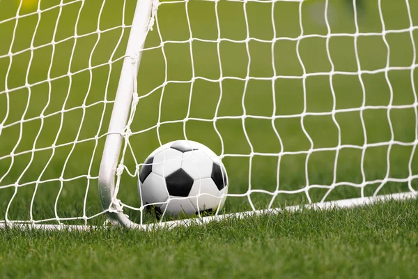 ゴールのサッカーボール サッカーボールは草の中に横たわる サッカー用具 ホワイトサッカーゴールとネット — ストック写真