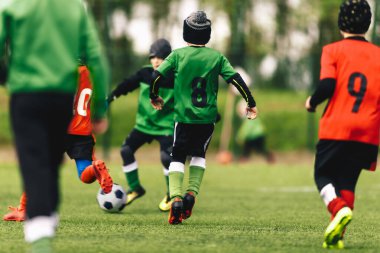 Genç çocuklar bir sonbahar gününde futbol oynuyorlar. Okul çocukları sonbahar futbol forması giyerek futbol oynuyor. Genç oğlanlar için futbol okulu