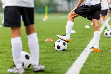 Futbol Eğitim Birimi. Siyah-Beyaz Futbol Giysilerinde Futbolcular Klasik Futbol Toplarını Tekmeliyor. Futbol Çim Atışı Antrenmanı. Okul Futbolu Eğitim Oturumu
