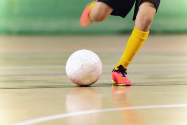 Futsal Oyuncu Tekmeleyen Topun yakın plan görüntüsü. İç saha futbol topu tekmesi. Kapalı alan futbol ekipmanları. Genç futbolcu Koşan ve Tekmeleyen Top