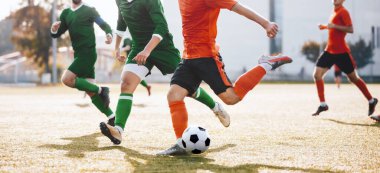 Yetişkin Futbolcular Topun ve Tekme Ligi Maçı 'nın peşinden koşuyor. Düelloda bir grup futbolcu. Turuncu ve Yeşil Jersey tişörtlü futbolcular