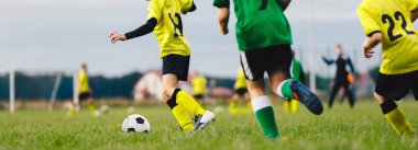 Football Players Running Classic Soccer Ball on Natural Grass Field. Soccer Summer Traing Camp For School Kids