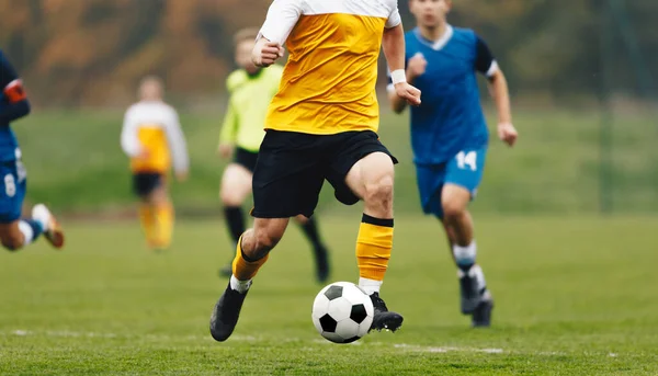 Adult Football Players Kicking Soccer Ball. Soccer Competition Between Two Teams. Soccer League Match. Player in Football Cleats in Run