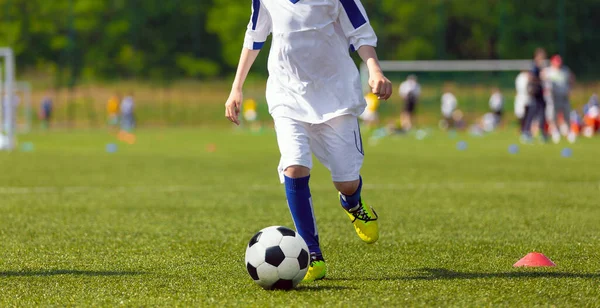 芝生の上でサッカーボールで走るスポーティキッド スポーツ水平背景 — ストック写真