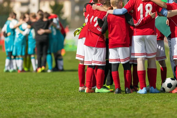 決勝戦の前にチームサークルに立っている2つのサッカーチーム 赤と青のサッカージャージーユニフォームの学校サッカー選手 コーチとの説明会でスポーツの子供 — ストック写真