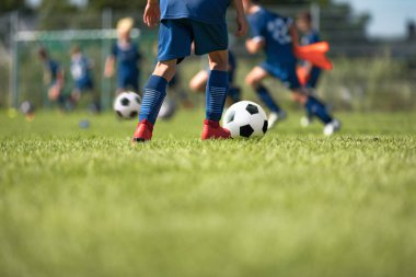 Çim okul bahçesinde futbol antrenmanı yapan bir grup çocuk. Spor giyim sektöründe futbol oynayan çocuklar