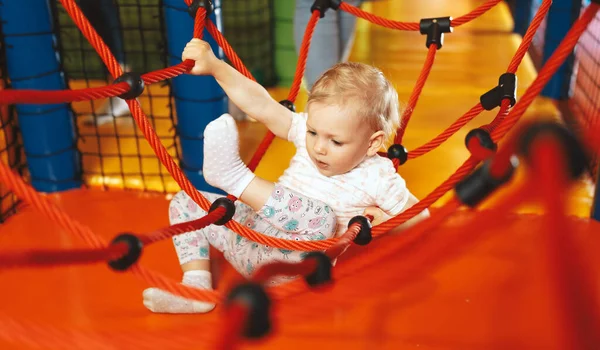 Lunaparkta iplerle oynayan heyecanlı küçük kız. Anaokulundaki renkli oyun parkında oynayan tatlı bir kız bebek. 