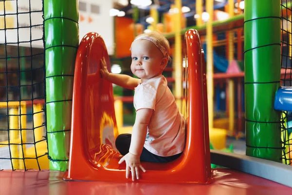 Bir lunaparktaki kaydırakta oynayan heyecanlı küçük kız. Anaokulundaki renkli oyun parkında oynayan tatlı bir kız bebek. 