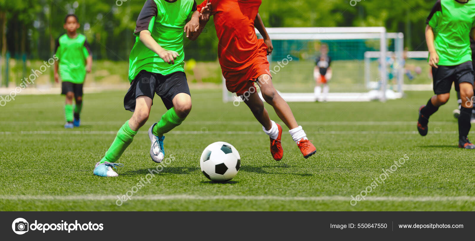 Jogadores de futebol adolescentes chutando bola de futebol campo