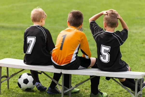 足球运动员坐在边凳上 学校足球队 年轻的足球运动员坐在替补席上观看比赛 — 图库照片