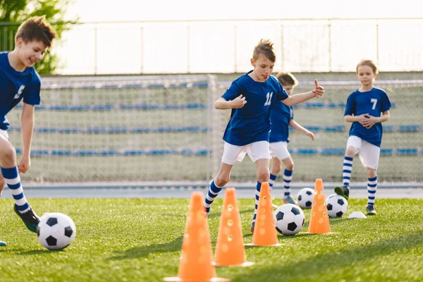 Happy Soccer Boys Running With Classic Balls on Training Slalom Drill. Kids Attending Soccer Class During Summer Football Camp