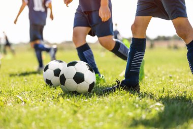 Güneşli bir günde Genç Okul Futbolcuları Tatbikatta Koniler Çevresinde Salya akıtıyor. Gençler için Futbol Eğitim Yaz Kampı. Avrupa Futbol Eğitim Birimi