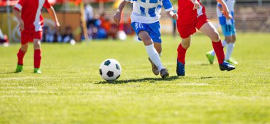Futbol Kırmızı ve Mavi Takım Spor Maçı. Yaz güneşli bir günde futbol maçı. Genç Çocuklar Turnuva Maçı 'nda yarışıyor. Okul çocukları Çimen Sahasında Klasik Futbol Topu koşuyor