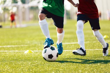 Çimen sahasında futbol oynayan iki çocuk. Turnuva sırasında Mutlu Okul Çocukları Balosu. Mavi ve Kırmızı Futbol Takımındaki Çocuklar