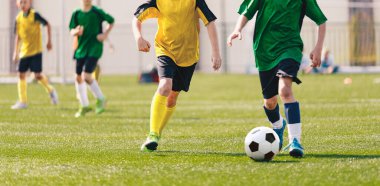 Yaz güneşli bir günde futbol maçı. Genç Çocuklar Turnuva Maçı 'nda yarışıyor. Okul çocukları Çimen Sahasında Klasik Futbol Topu koşuyor