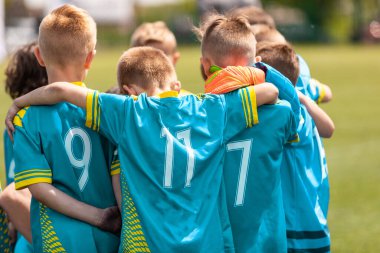 Gençlik sporları koçu, futbol sahasındaki çocukları büyülüyor. Çocuklar final maçından önce birbirlerine sokuluyorlar. Çocuklar toplanmış eğiliyor.