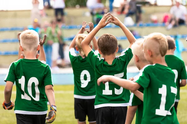 男子サッカーチームが勝利を祝う やる気のある子供スポーツチームが手を挙げています 屋外の芝生のピッチ上の若い学校サッカーチーム スポーツをする幸せな子供たち — ストック写真
