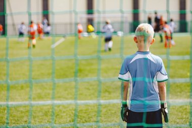 Young Boy Standing in Soccer Goal Wearing Football Goalkeeper Shirt and Gloves. Kids Play Football Game. Children Play Sports Tournament Game