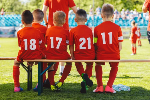 Jogadores Futebol Equipe Jovens Sentados Banco Madeira Miúdos Camisas Vermelhas — Fotografia de Stock