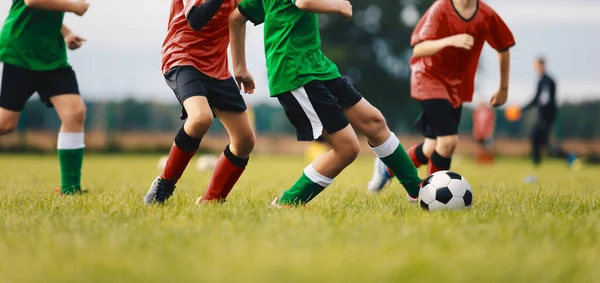 子供たちはサッカーゲームをする サッカーの古典的なボールを蹴る2つのチームの子供たち ユースサッカー選手が夏のサッカー試合で楽しんでいる — ストック写真