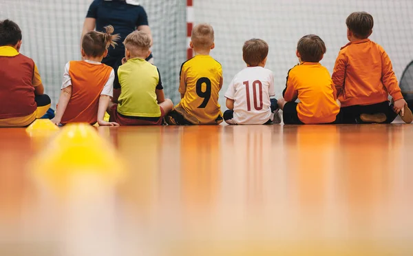 Little boys at class with young physical education teacher. Happy kids at school sports hall. Children at sports training practice