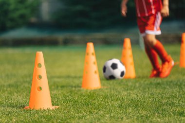 Futbol antrenman konileri sırası. Genç Futbolcu Slalom Taliminde Hızlı ve Tekmeleyen Futbol Topu