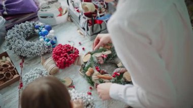 Eller masanın üstüne. Süslü bir Noel çelengi al..