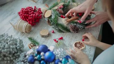 Eller masanın üstüne. Süslü bir Noel çelengi al..