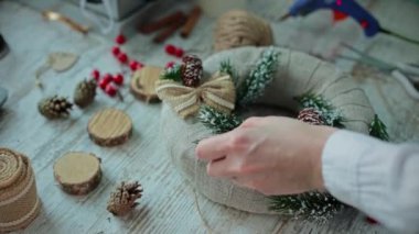 Eller masanın üstüne. Süslü bir Noel çelengi al..