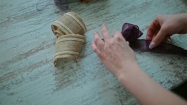 Yakın çekim eller dekoratif kurdeleden yapılmış bir yayı düzeltir..