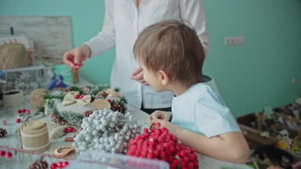 Dívka a dítě sbírají vánoční věnec společně. — Stock video
