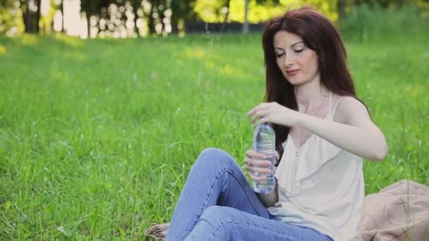 Жінка п'є воду з пляшки — стокове відео