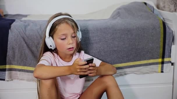 Niño alegre escuchando música en auriculares — Vídeos de Stock