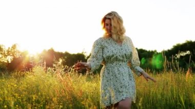 Bir kadın yeşil bir çayırda yürüyor.