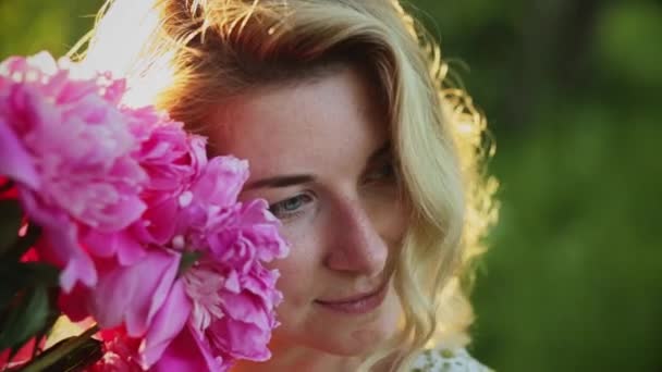 Close-up portrait Woman with long hair with a bouquet of peonies. — Stock Video