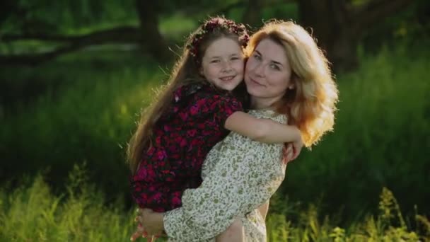Молодая женщина и ребенок обнимаются в поле — стоковое видео