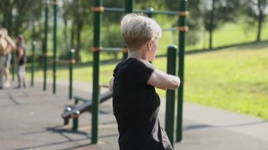 Yaşlı bir kadın oyun parkında ısınıyor..