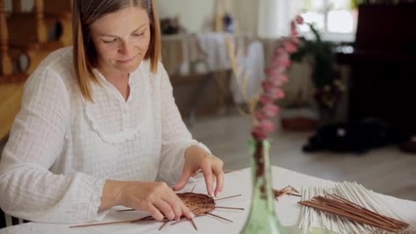 Volwassen vrouw het maken van papier wijnstok mand thuis — Stockvideo