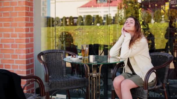 Girl sit in a cafe on the street drinking tea. — Vídeo de Stock
