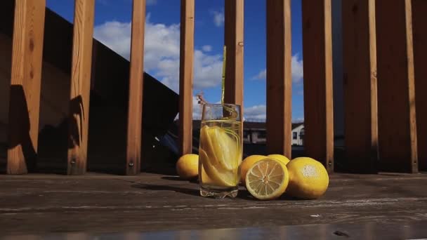 Studená voda s citronem ve sklenici se slámou. — Stock video