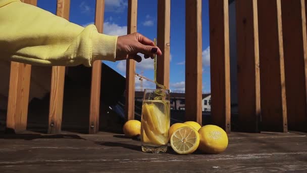 Agua fría con limón en un vaso con paja. — Vídeos de Stock