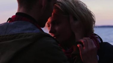 Güneşli bir günde plajda sevgilisiyle genç bir adam.