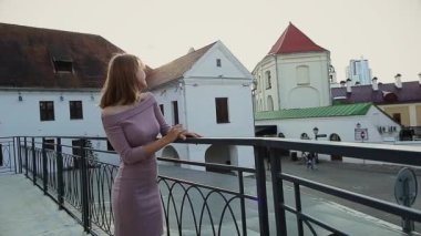 Güneşli bir günde çatıda gülümseyen genç bir kadın.