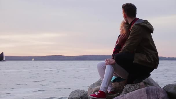 Couple looking at sea while sitting on rock — Stock Video