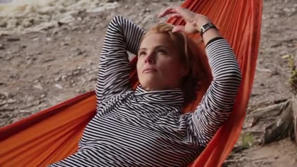 Kumsaldaki hamakta yatan olgun sarışın kadın. — Stok video