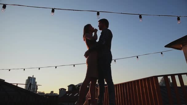 Casal beijando enquanto estava em pé no telhado durante o pôr do sol — Vídeo de Stock