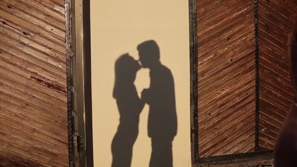 A parede reflete as sombras dos amantes se beijando ao pôr do sol. silhuetas frescas — Vídeo de Stock