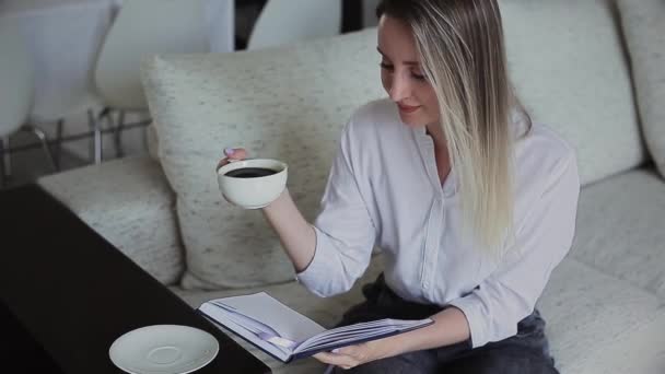 Hermosa chica leyendo y bebiendo café — Vídeo de stock