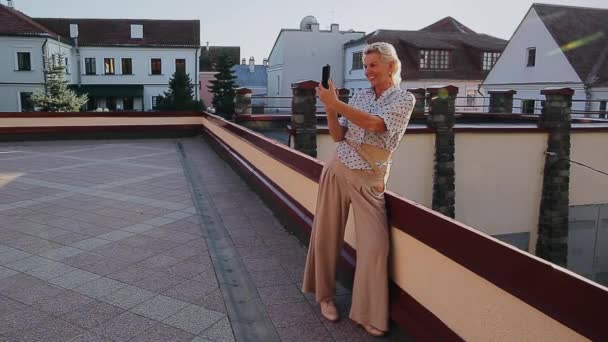 Старша жінка бере селфі через смартфон на даху — стокове відео