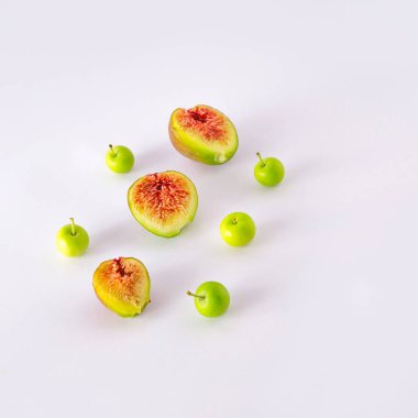 Beyaz bir masaya dizilmiş incir ve elmalar. En düşük meyve asimetrik bileşimi.